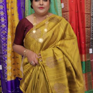 Mustard-gold raw silk saree featuring intricate traditional woven motifs and a rich silk sheen
